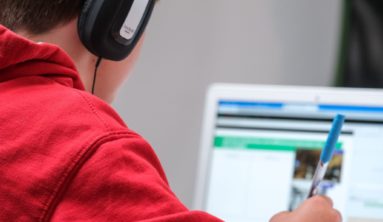 person in red shirt wearing black and gray headphones