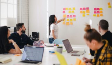 woman placing sticky notes on wall