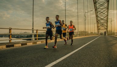 four men running on asphalt floor