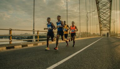 four men running on asphalt floor